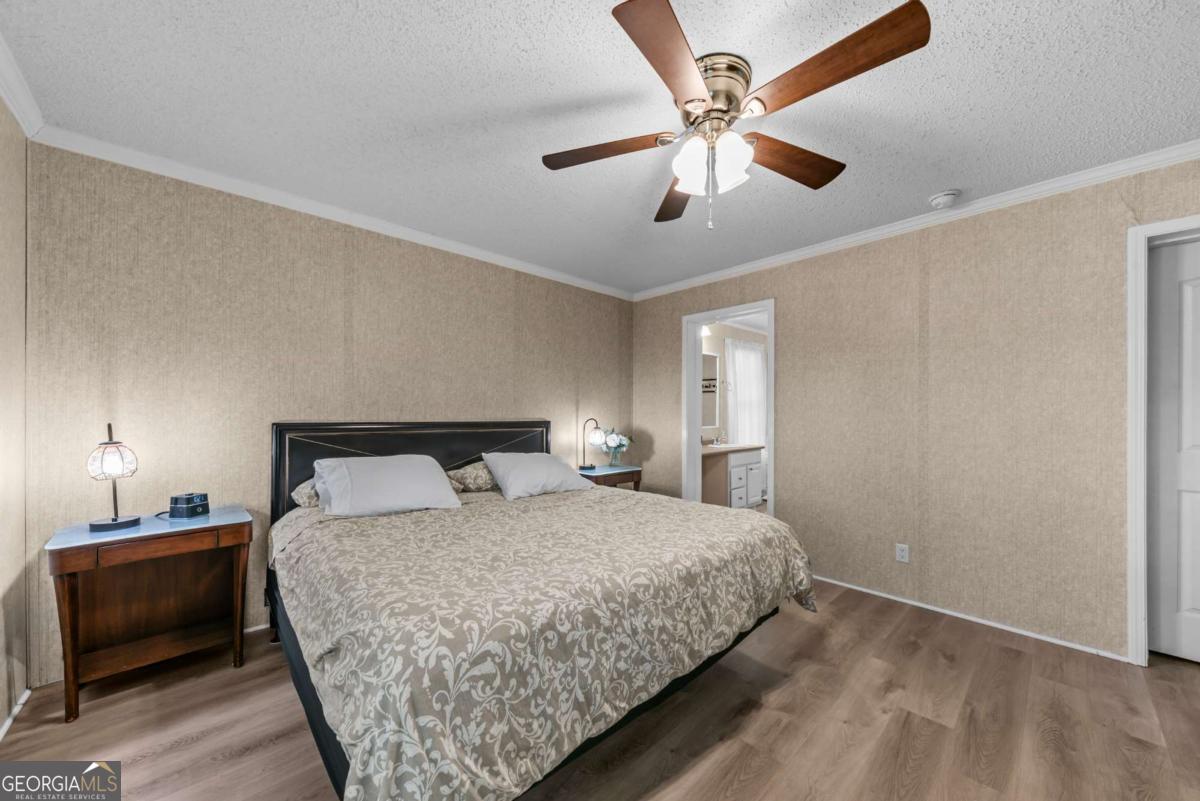 194 Phillips Road Eatonton, GA 31024 - Photo 22 of 57 a bedroom with a bed and a lamp on the dresser
