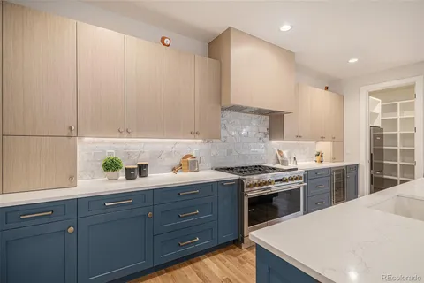 a kitchen with a stove a sink a refrigerator and cabinets