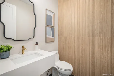a bathroom with a sink vanity mirror and toilet