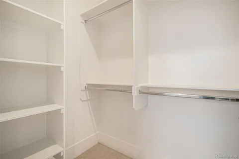a view of walk in closet with empty racks