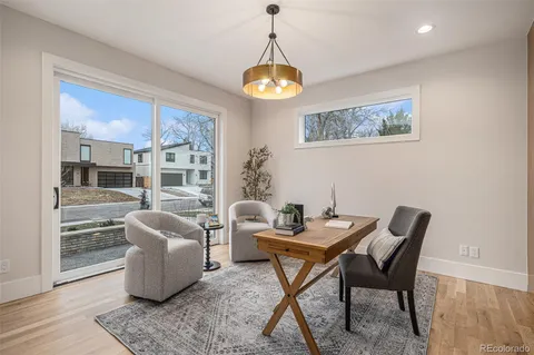 a dining room with furniture a chandelier and wooden floor