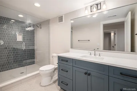 a bathroom with a sink toilet a mirror and shower