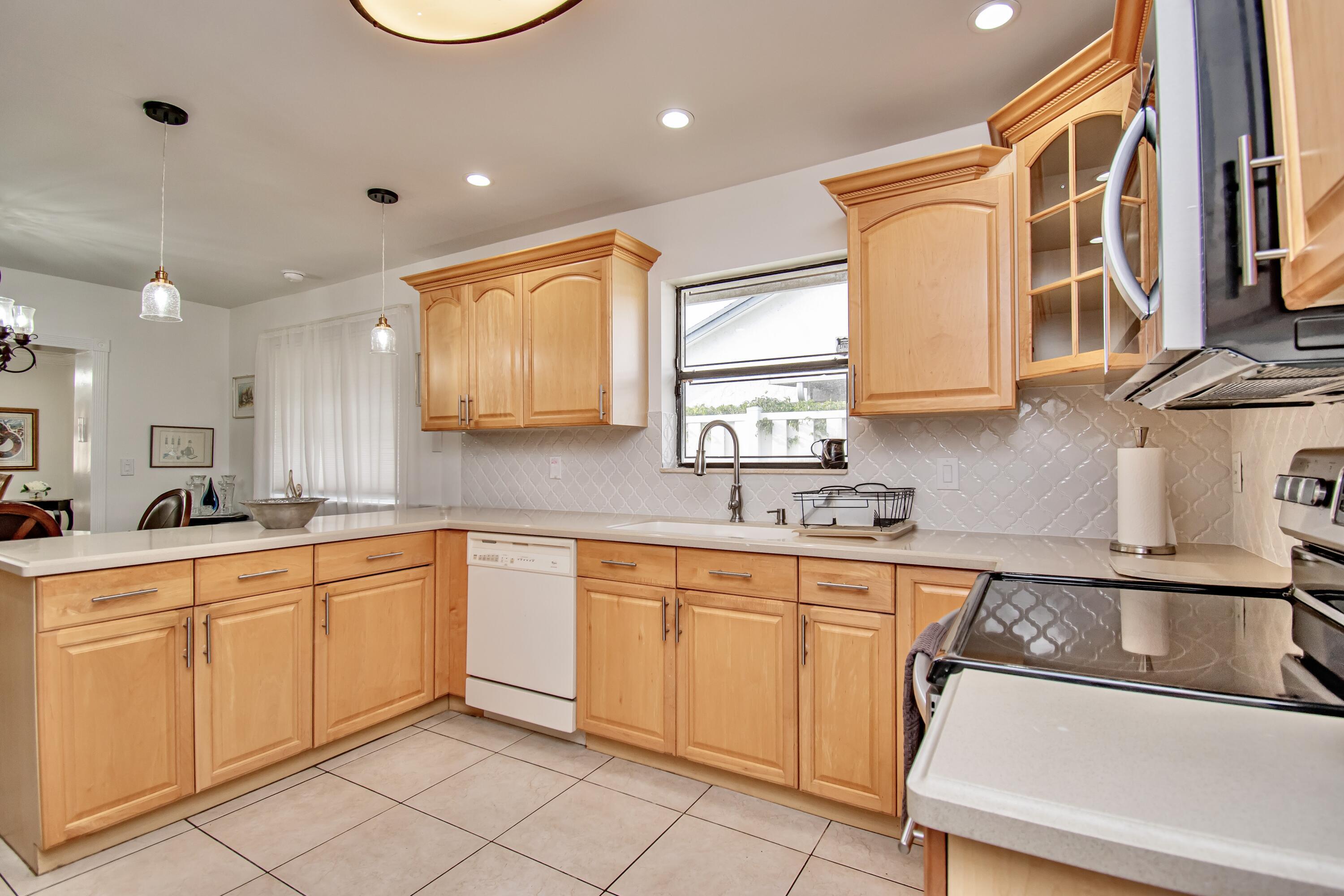 7838 Cypress Crescent Boca Raton, FL 33433 - Photo 10 of 24 a kitchen with white cabinets a sink and appliances
