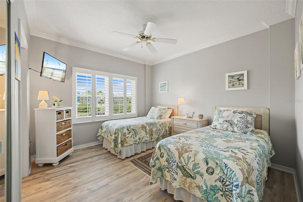 399 150th Avenue, Unit 309 Madeira Beach, FL 33708 - Photo 15 of 43 a bedroom with two beds and a chandelier