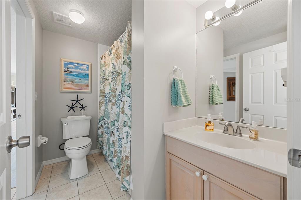 399 150th Avenue, Unit 309 Madeira Beach, FL 33708 - Photo 16 of 43 a bathroom with a sink a toilet and a large mirror