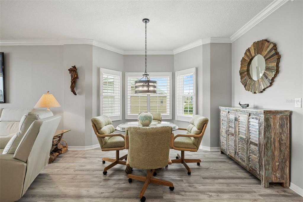 399 150th Avenue, Unit 309 Madeira Beach, FL 33708 - Photo 8 of 43 a view of a dining room with furniture window and wooden floor
