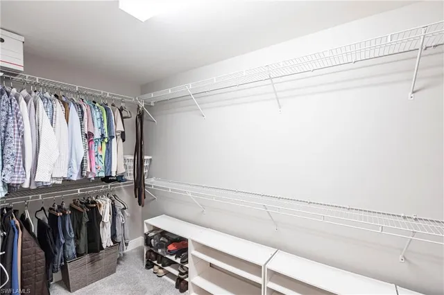 a view of walk in closet with clothes and shoes