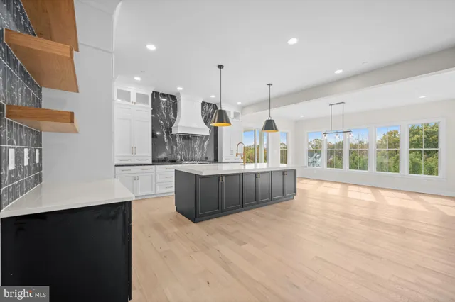 a large kitchen with a large counter top and stainless steel appliances