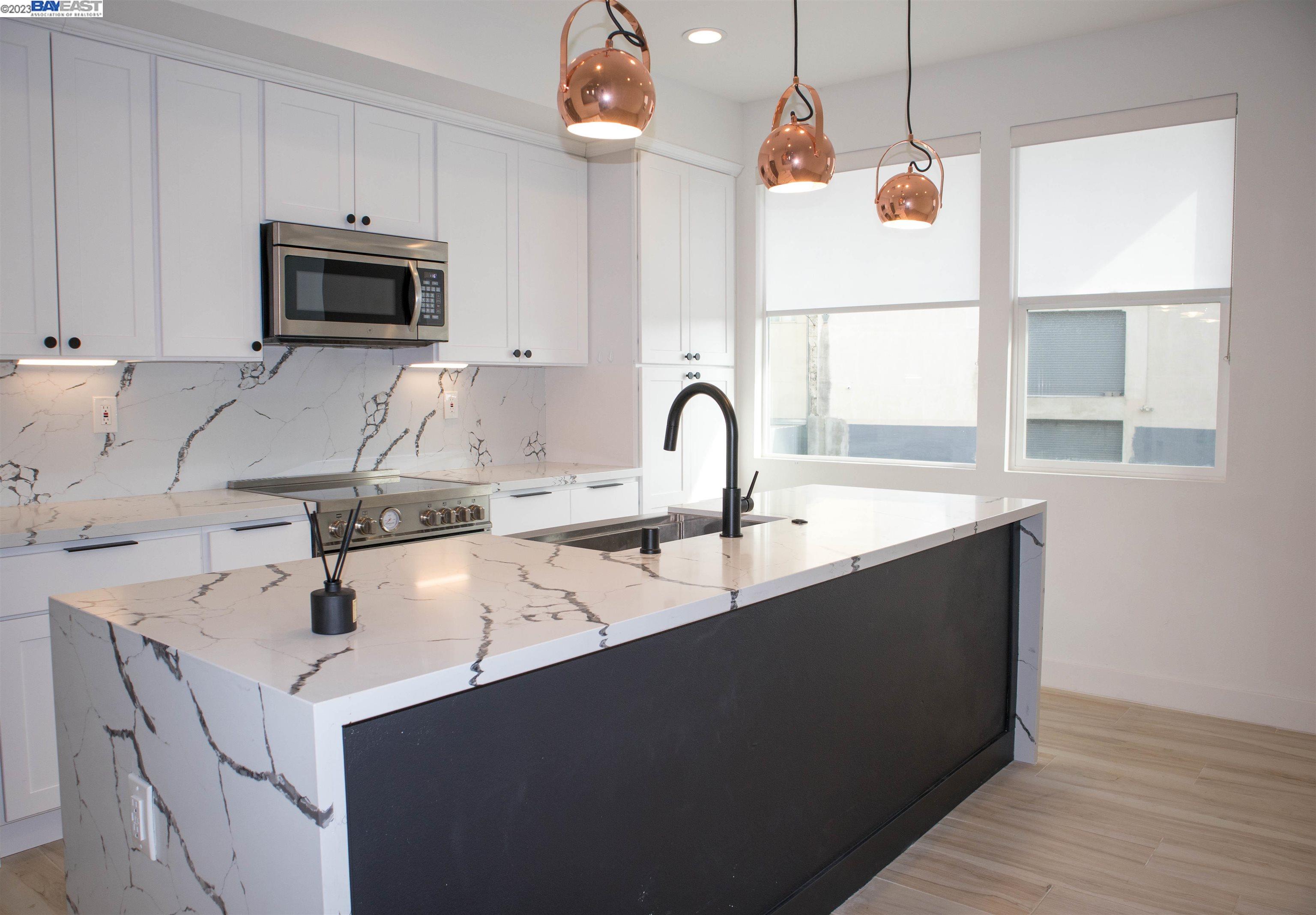 a kitchen with a sink a microwave and cabinets