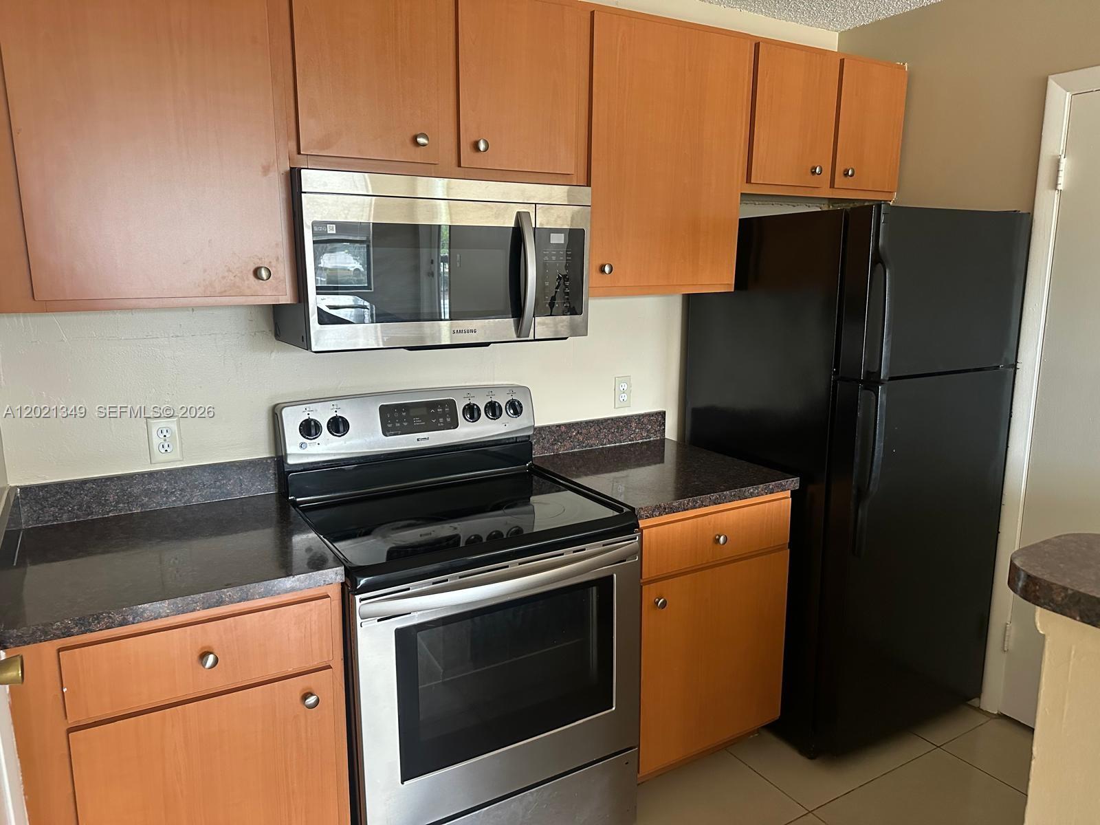 4481 West McNab Road, Unit 37 Pompano Beach, FL 33069 - Photo 11 of 20 a kitchen with stainless steel appliances white cabinets and a stove