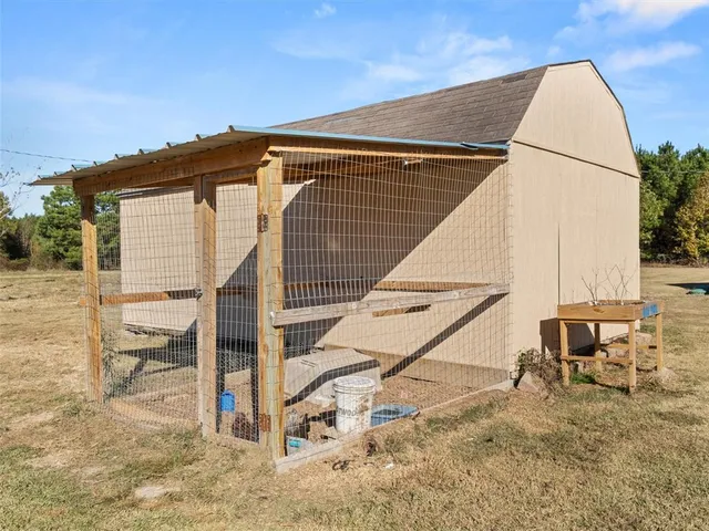 a view of house with wooden deck and furniture