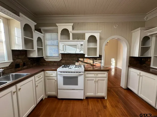 a kitchen with stainless steel appliances granite countertop a stove a sink and a microwave