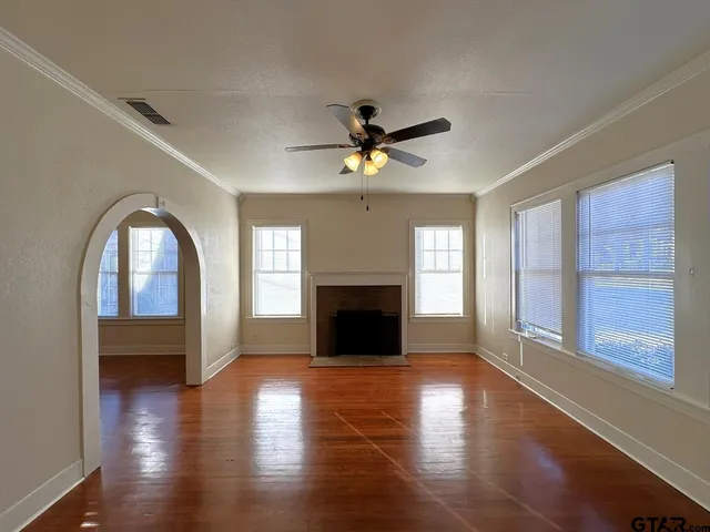 a view of a livingroom with a fireplace wooden floor and a window