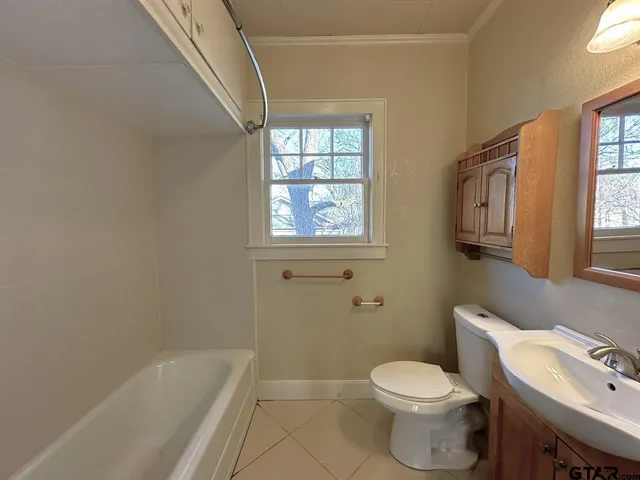 a white toilet sitting next to a bath tub