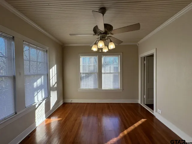 a view of a livingroom with wooden floor and a ceiling fan