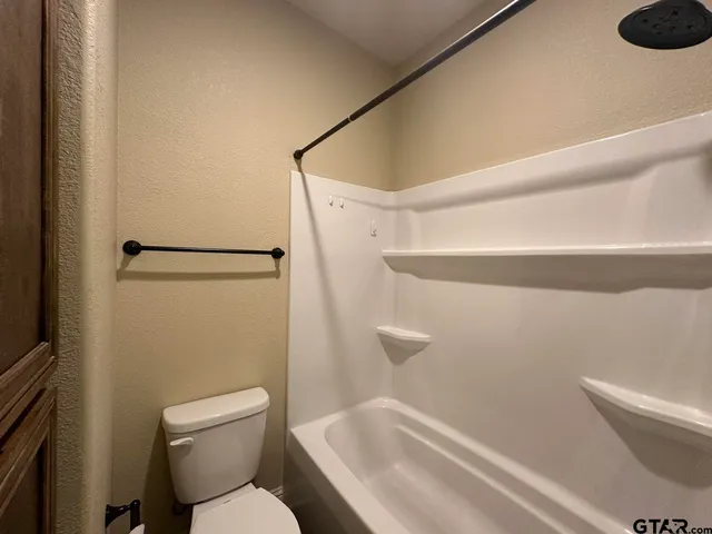 an empty room with wooden floor closet and windows
