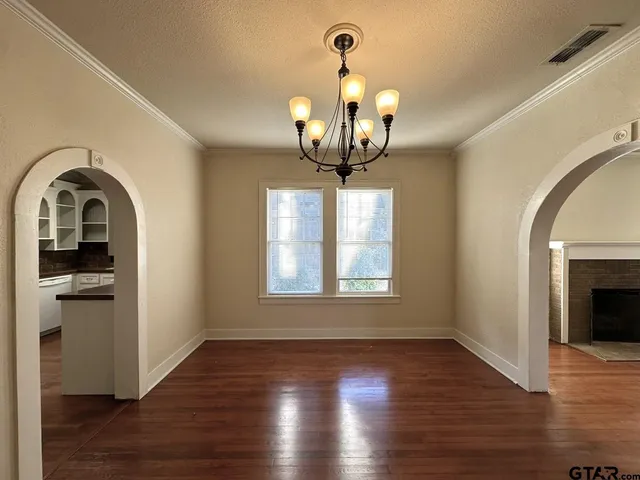 a view of a big room with wooden floor chandeliers and kitchen