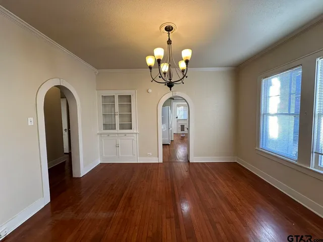a view of a room with wooden floor chandelier and entryway