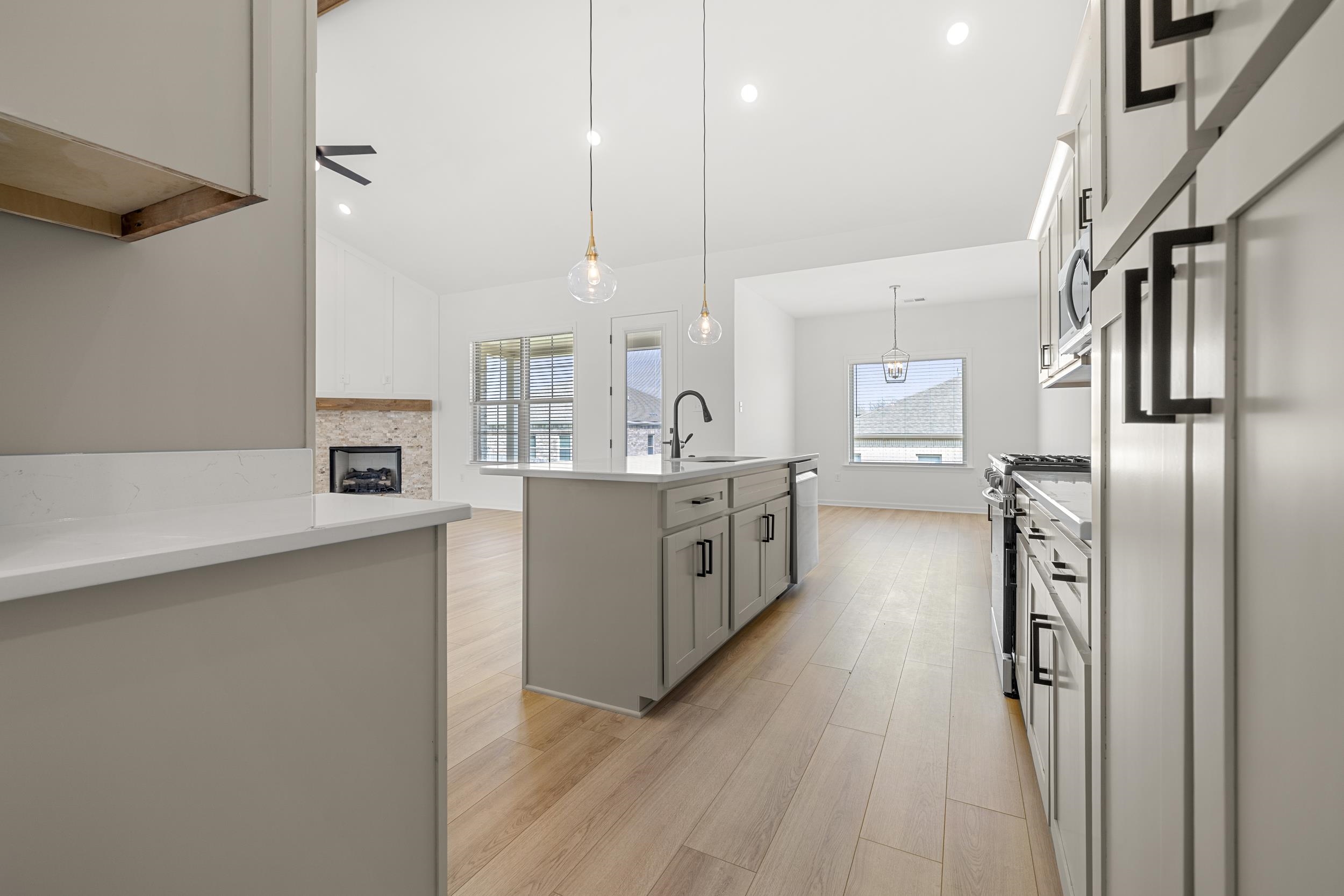 140 Oakland Rdg Cove Oakland, TN 38060 - Photo 9 of 30 Kitchen with an island with sink, stainless steel appliances, hanging light fixtures, light wood-style floors, and healthy amount of natural light