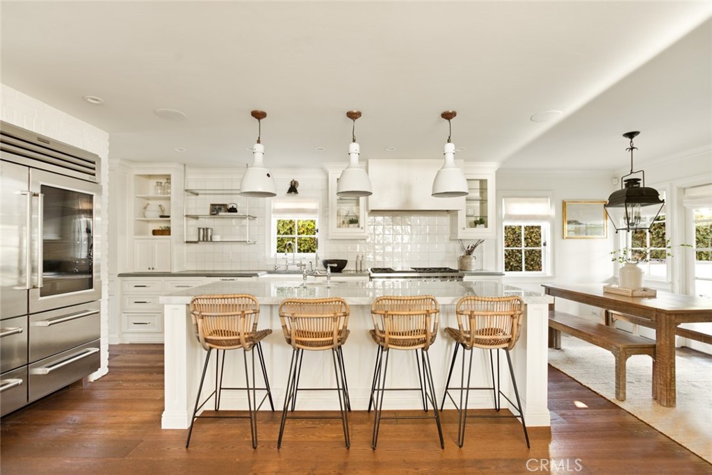 326 Ruby Street Laguna Beach, CA 92651 - Photo 13 of 71 a kitchen with stainless steel appliances kitchen island granite countertop a dining table chairs and white cabinets