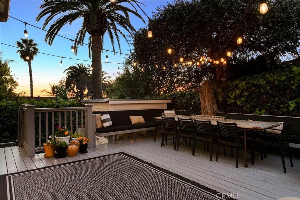 326 Ruby Street Laguna Beach, CA 92651 - Photo 69 of 71 a view of a roof deck with table and chairs couches with wooden floor and fence
