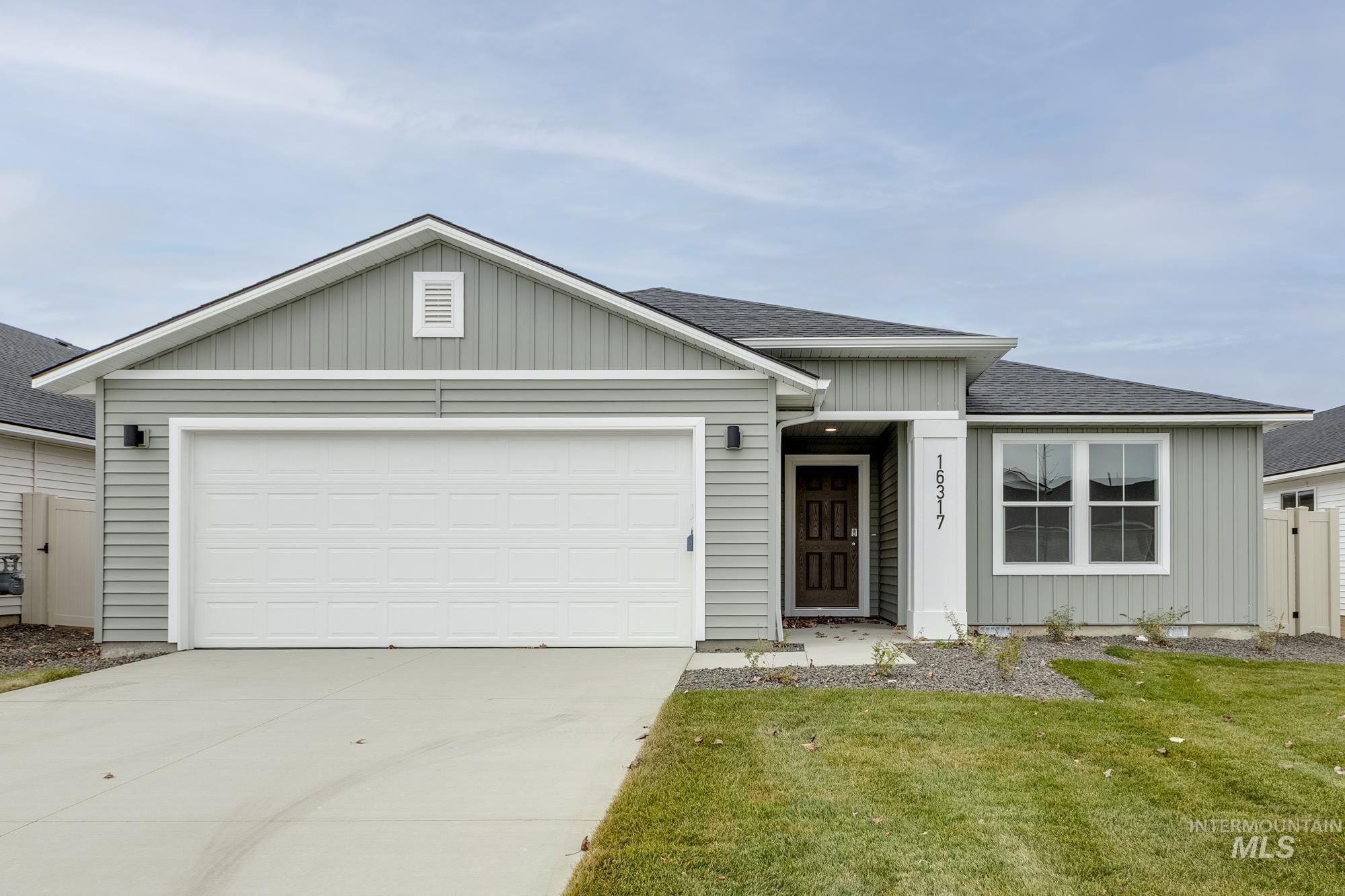 Ranch-style house featuring roof with shingles, board and batten siding, concrete driveway, and a garage