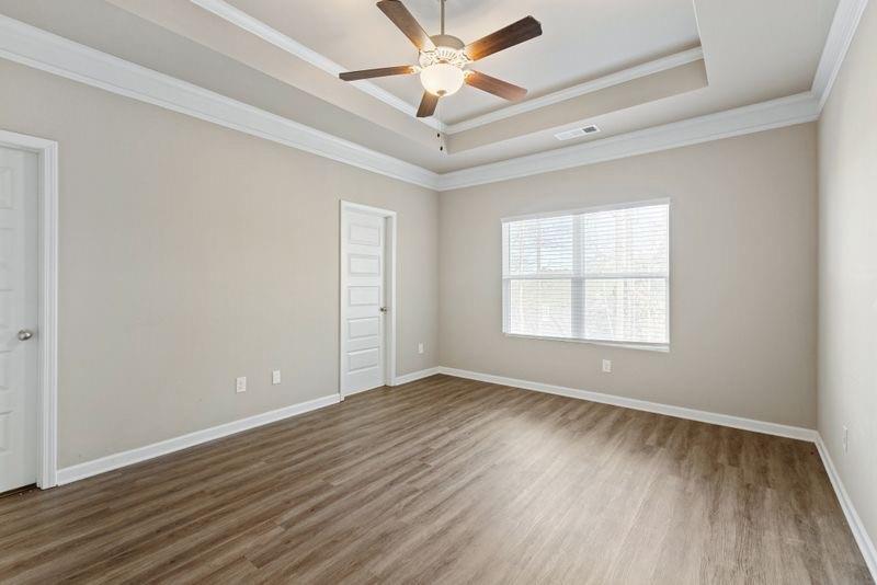 760 McCart Road Lawrenceville, GA 30045 - Photo 21 of 40 an empty room with wooden floor chandelier fan and windows