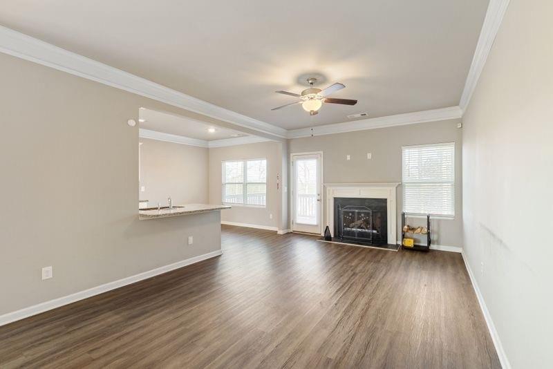 760 McCart Road Lawrenceville, GA 30045 - Photo 7 of 40 an empty room with wooden floor fireplace and windows