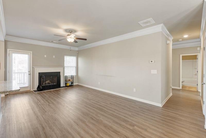760 McCart Road Lawrenceville, GA 30045 - Photo 8 of 40 an empty room with wooden floor fireplace and windows