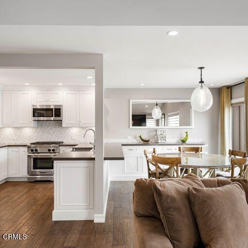 3241 Harbor Boulevard Oxnard, CA 93035 - Photo 11 of 32 a large kitchen with stainless steel appliances kitchen island granite countertop a stove and a sink