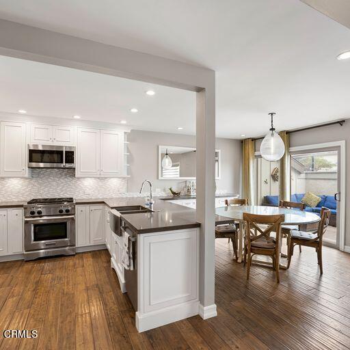 3241 Harbor Boulevard Oxnard, CA 93035 - Photo 14 of 32 a kitchen with stainless steel appliances granite countertop wooden floor a stove cabinets a sink and chairs