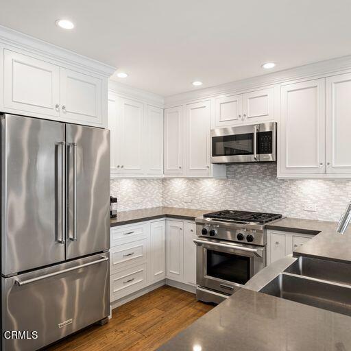 3241 Harbor Boulevard Oxnard, CA 93035 - Photo 9 of 32 a kitchen with cabinets stainless steel appliances and wooden floor