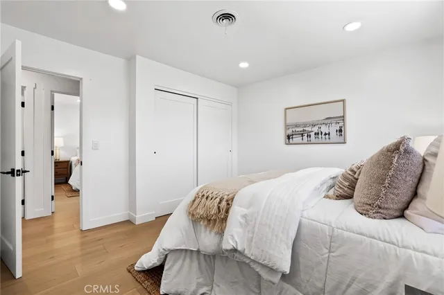 a bedroom with a large bed and wooden floor