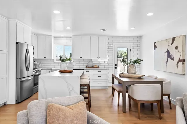 a kitchen with white cabinets and stainless steel appliances