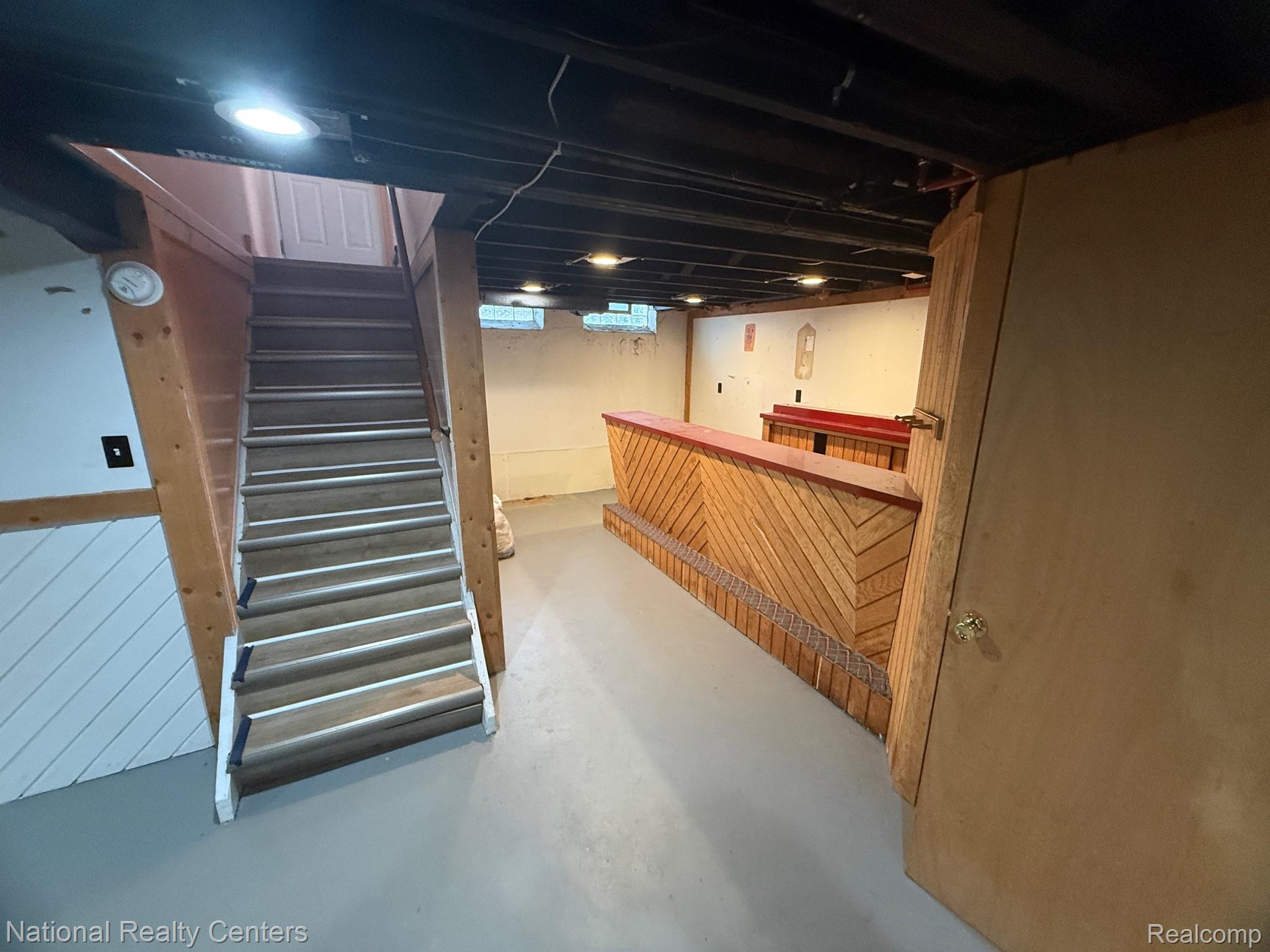 9920 Farmington Road Livonia, MI 48150 - Photo 16 of 20 Lower level featuring a built-in bar with wood paneling, recessed lighting, and a painted concrete floor