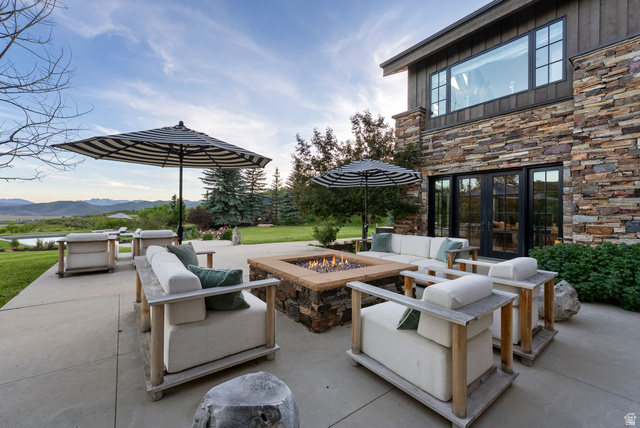 5971 Maple Ridge Trail Oakley, UT 84055 - Photo 7 of 43 Expansive outdoor patio featuring a built-in fire pit with stone and wood-finish detailing