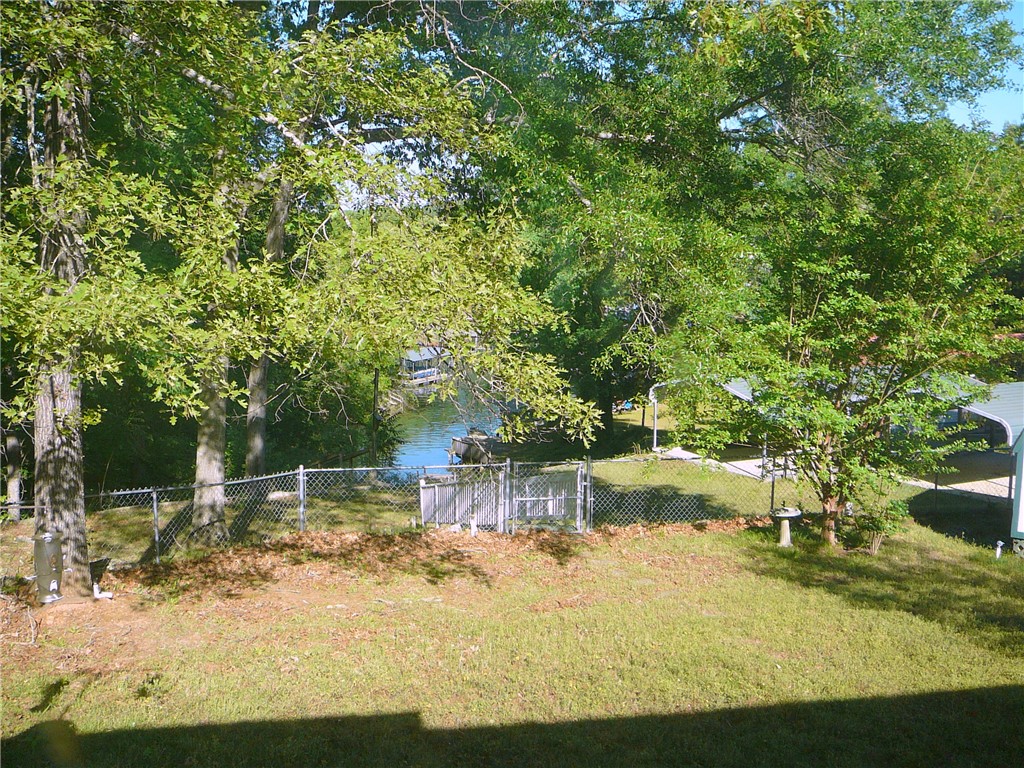 11 Waterford Point Iva, SC 29655 - Photo 25 of 27 This tranquil waterfront property features mature trees, a well-maintained lawn, and a chain link fence.