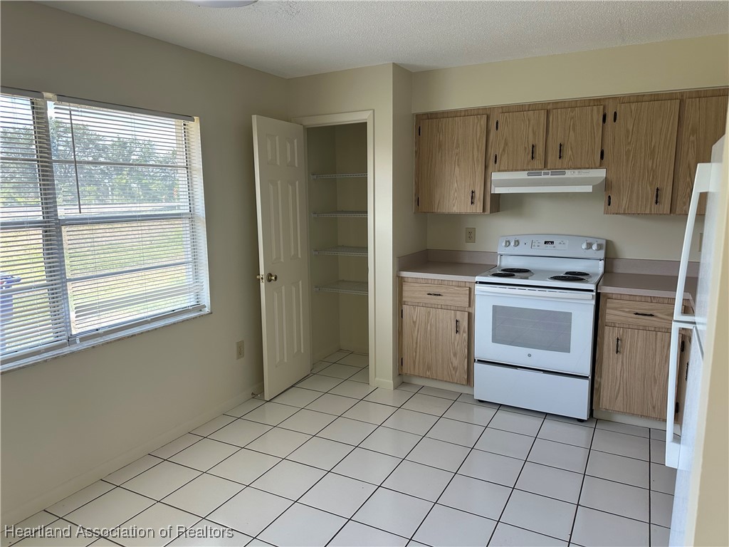 7422 Valencia Road Sebring, FL 33876 - Photo 5 of 15 a kitchen with a stove sink and a refrigerator