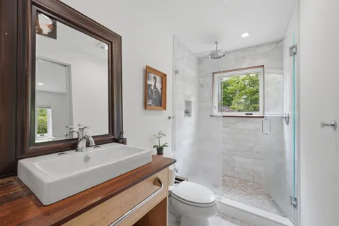a bathroom with a sink a toilet and shower