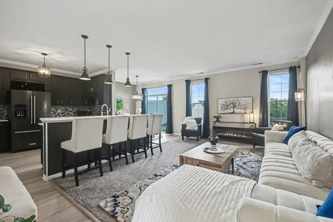 a living room with furniture a dining table and a chandelier