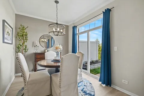 a dining room with furniture a chandelier and wooden floor
