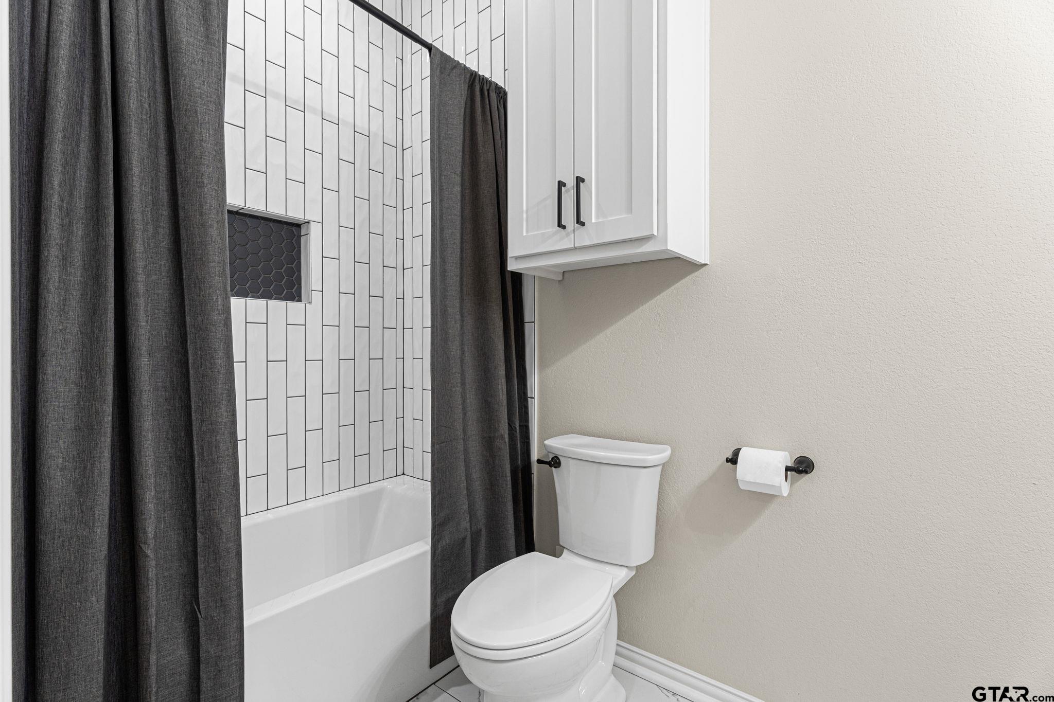 12293 Harlon Street Flint, TX 75762 - Photo 20 of 33 a white toilet sitting next to a bathroom sink