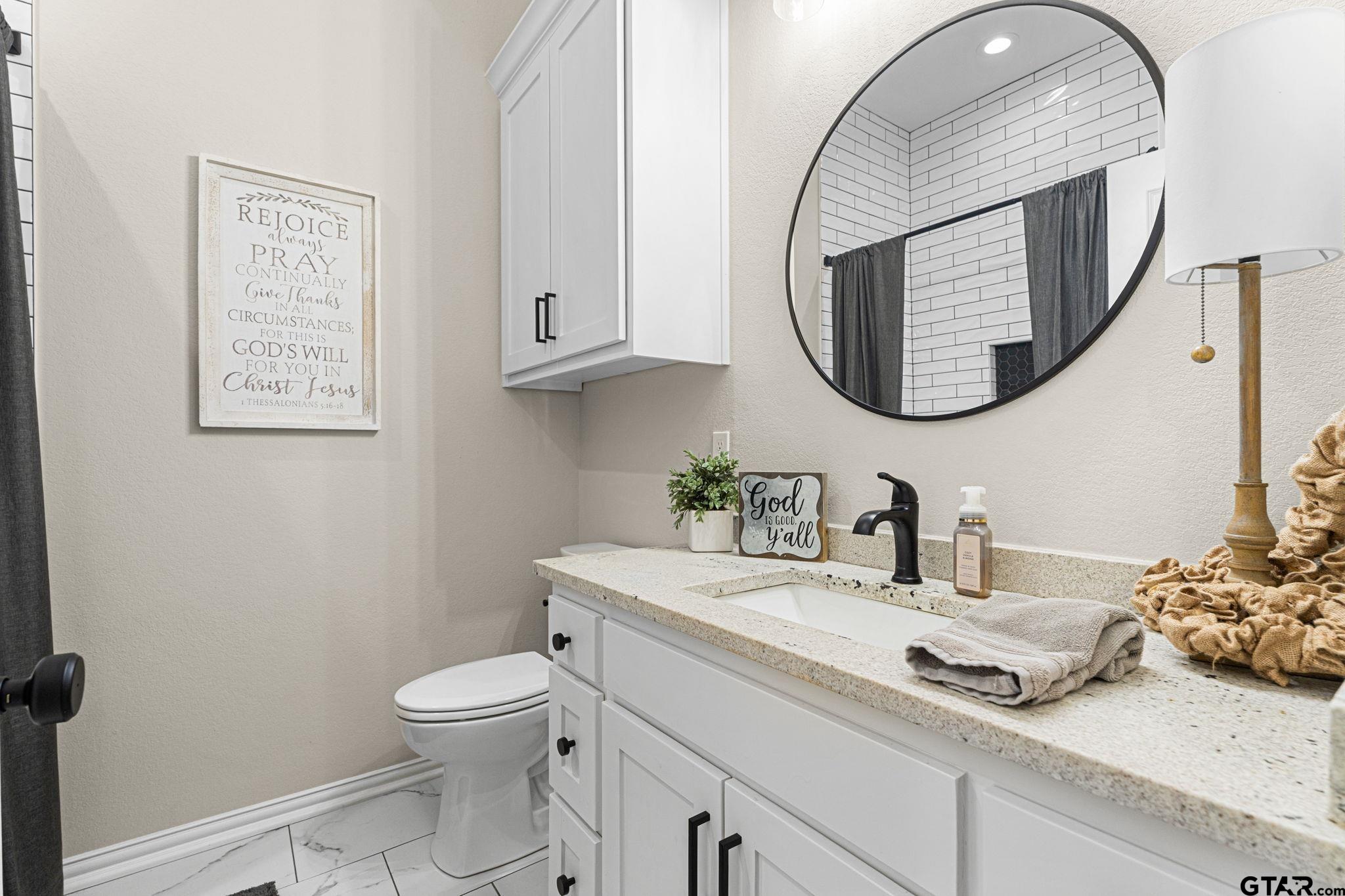 12293 Harlon Street Flint, TX 75762 - Photo 23 of 33 a bathroom with a toilet a sink and mirror