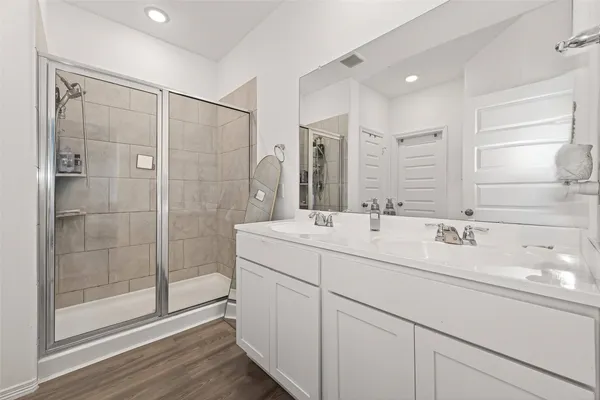 a bathroom with a shower sink and mirror