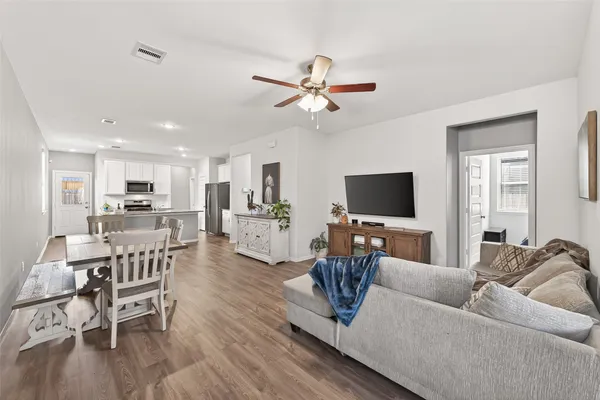 a living room with furniture kitchen view and a flat screen tv