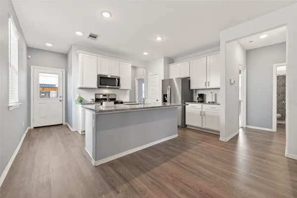 a kitchen with cabinets wooden floor and a sink