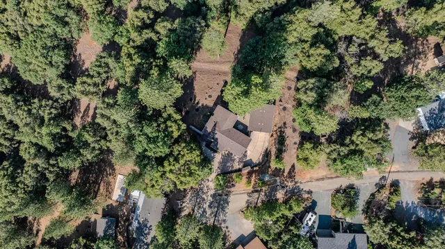 an aerial view of a house with a yard and trees