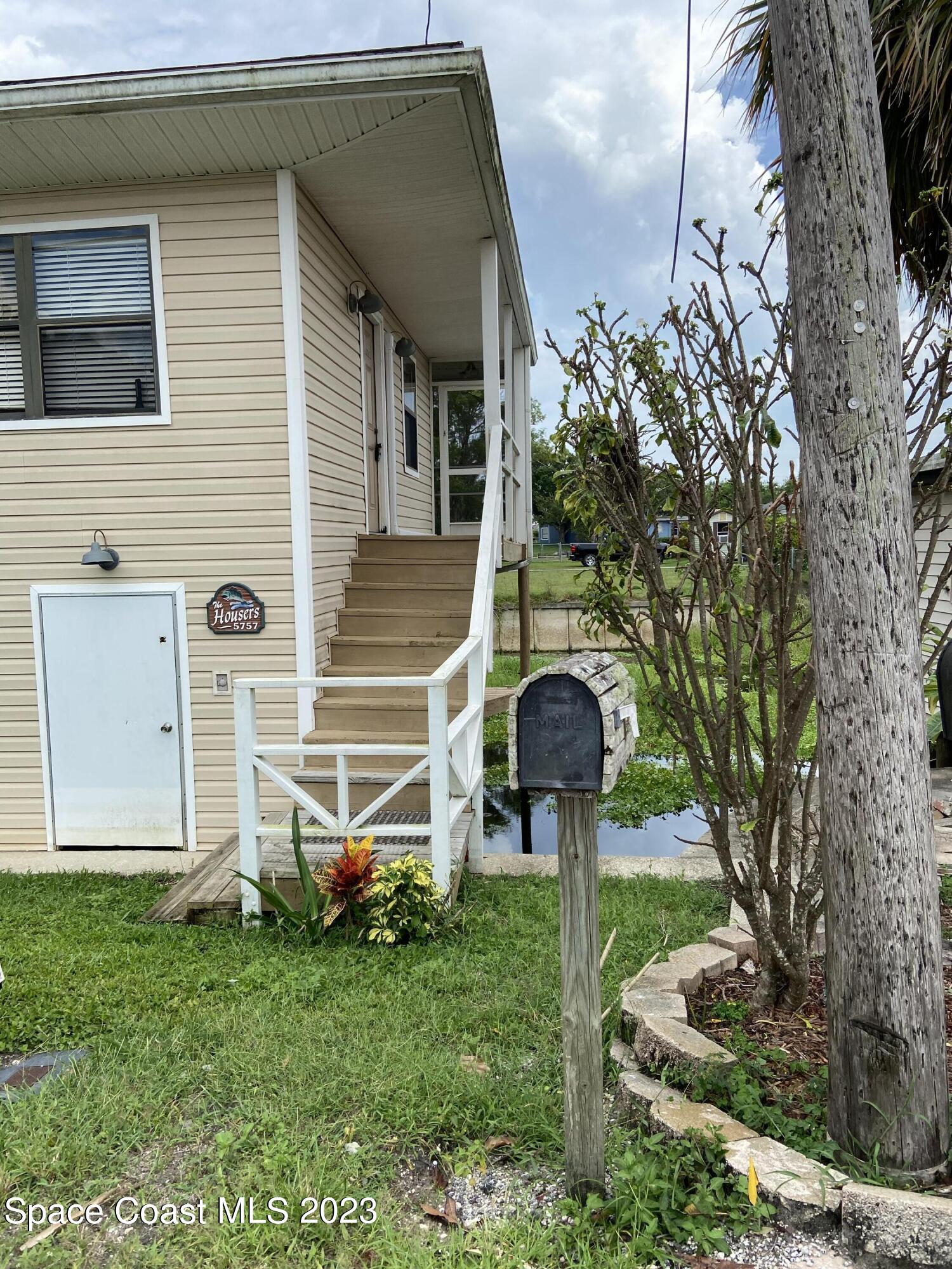 5757 Lake Poinsett Road Cocoa, FL 32926 - Photo 3 of 43 a front view of a house with a garden and plants