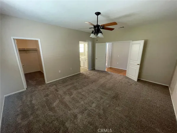 an empty room with closet and fan