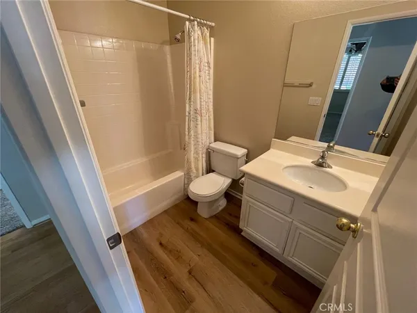 a bathroom with a sink a toilet a mirror and shower